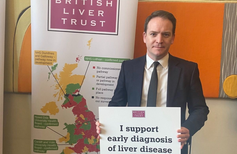 Gareth Davies MP holding a sign in support of the early diagnosis of liver disease