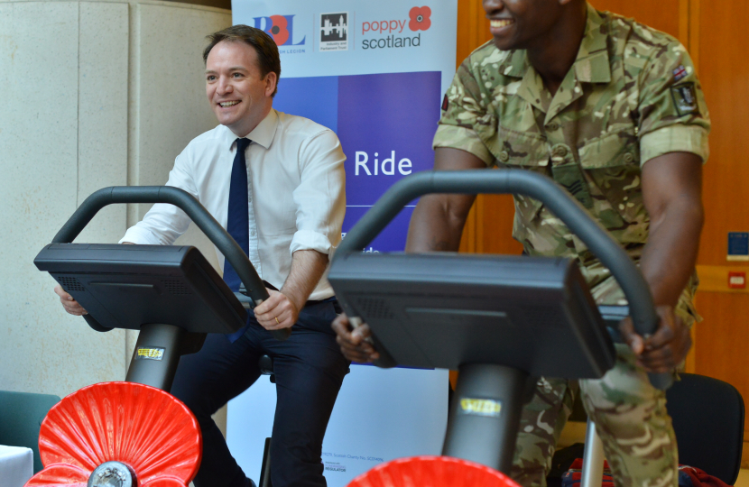 Gareth Davies MP on an exercise bike alongside a soldier