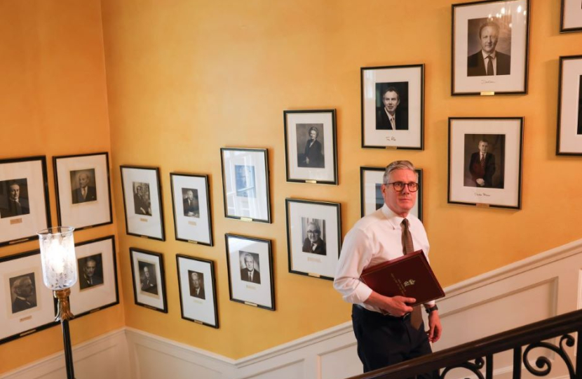 Sir Keir Starmer walks up the staircase in No.10 alongside portraits of previous Prime Ministers, including Clement Attlee