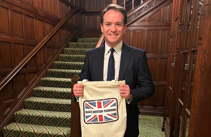 Gareth Davies MP holding a bag reading 'Back British Farming'