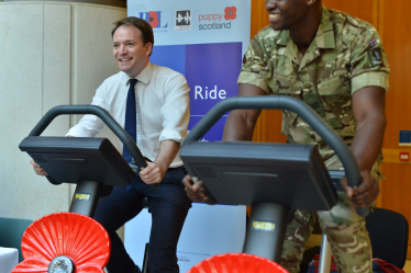 Gareth Davies MP on an exercise bike alongside a soldier