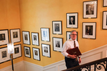 Sir Keir Starmer walks up the staircase in No.10 alongside portraits of previous Prime Ministers, including Clement Attlee