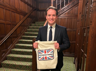 Gareth Davies MP holding a bag reading 'Back British Farming'